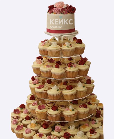 Прекрасный свадебный торт с цветами и капкейками Прекрасный свадебный торт с цветами и капкейками Фото