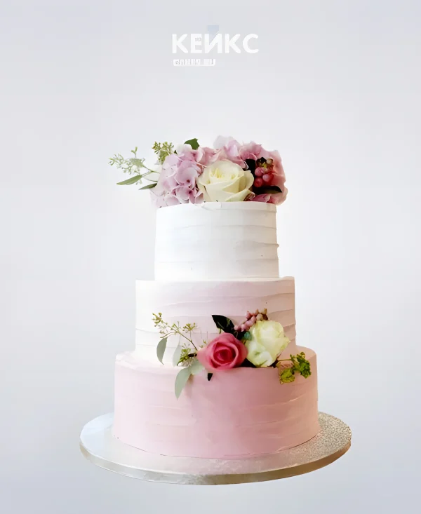 Маленький нежно-розовый свадебный торт с букетами живых цветов Фото