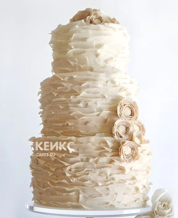 Воздушный бежевый свадебный торт с цветами и рюшами Фото