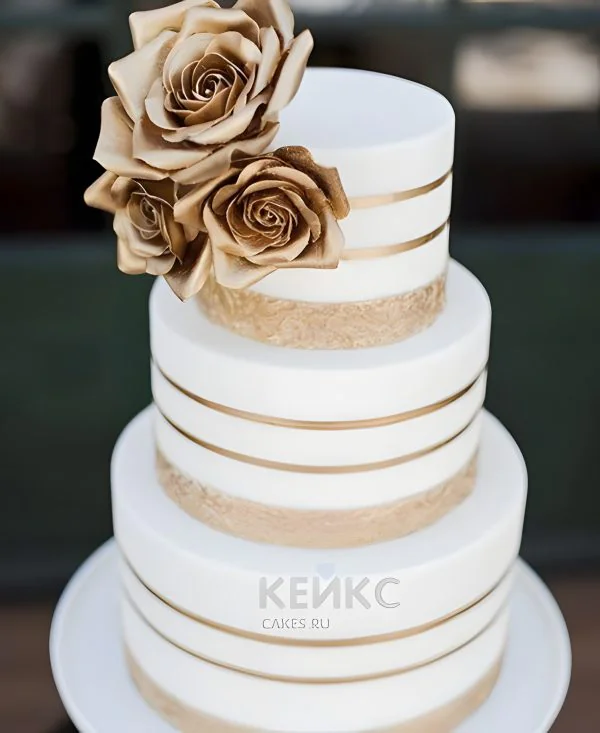 Высокий свадебный торт с золотыми цветами и полосами Фото