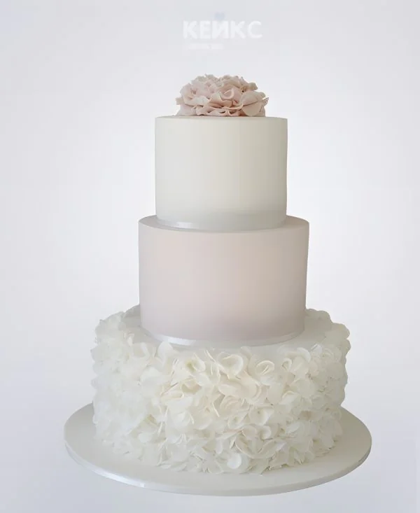 Воздушный белый свадебный торт с кружевами и цветком Воздушный белый свадебный торт с кружевами и цветком Фото
