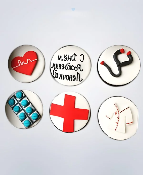 Капкейки с надписью и красным крестом для врача Фото