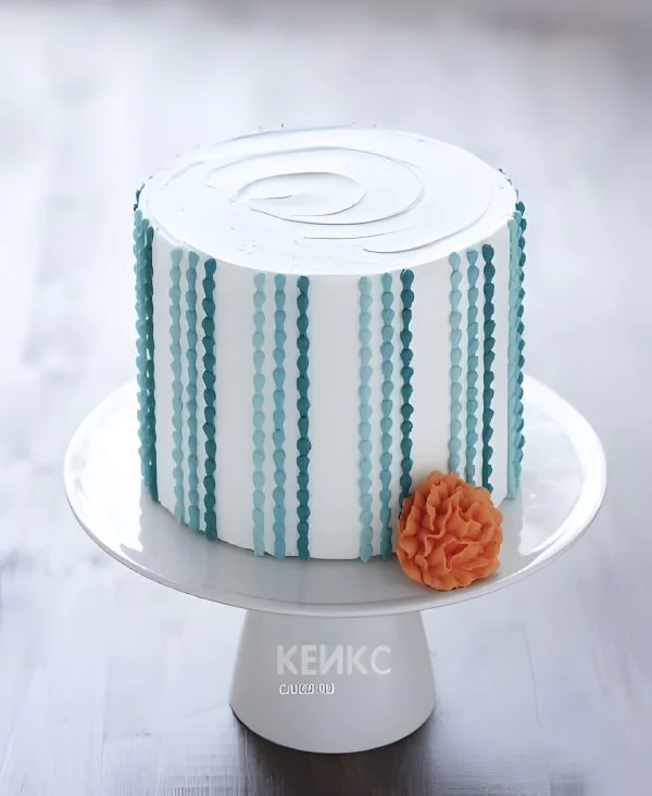 Белый торт с голубыми полосами и цветком Фото