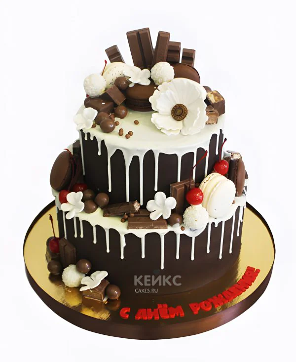 Шоколадный торт со сладостями и белыми цветами Шоколадный торт со сладостями и белыми цветами Фото