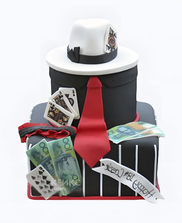 Стильный черный торт с белой шляпой и красным галстуком Стильный черный торт с белой шляпой и красным галстуком Фото