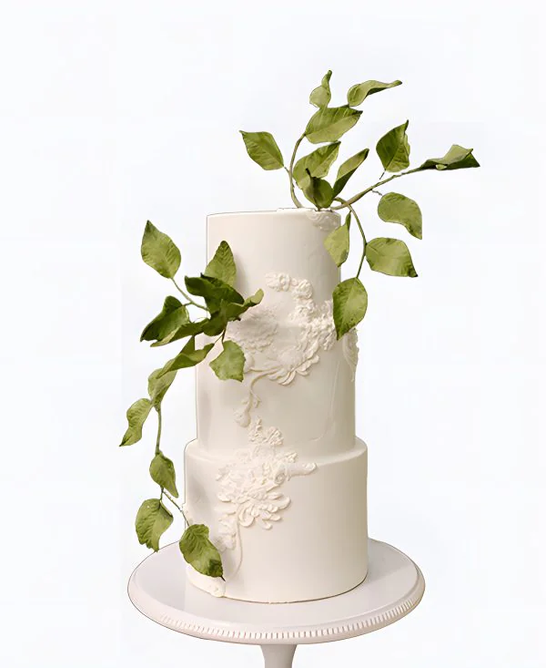 Трендовый торт на свадьбу с узорами и зелеными листьями Трендовый торт на свадьбу с узорами и зелеными листьями Фото