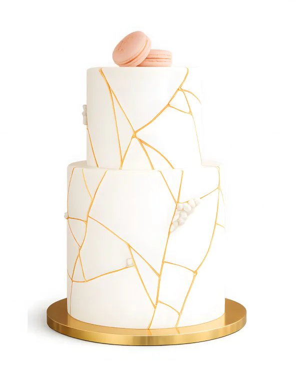 Двухъярусный свадебный торт с мастикой с макарон и узорами из золота Фото