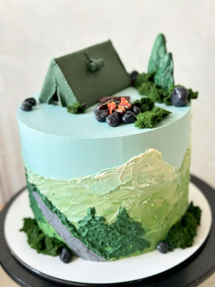 Голубой торт с рисунком гор и палаткой Фото